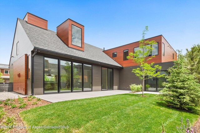 back of property with a patio area and a lawn