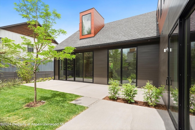 rear view of house featuring a patio and a lawn