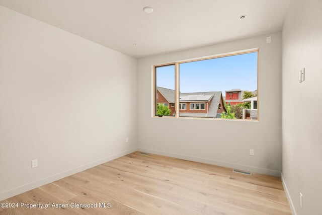 unfurnished room with light wood-type flooring