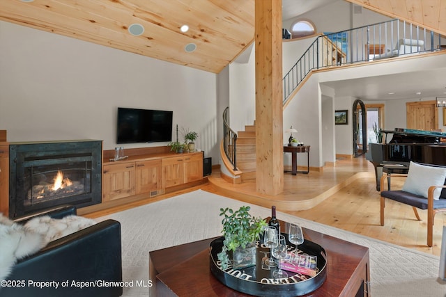 554 Sinclair Rd, Snowmass Village, CO 81615 - living area with stairway, wood finished floors, high vaulted ceiling, and a glass covered fireplace