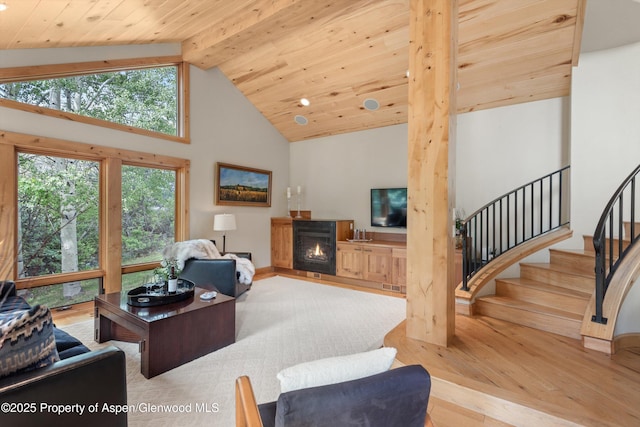 554 Sinclair Rd, Snowmass Village, CO 81615 - living room featuring wood finished floors, high vaulted ceiling, a lit fireplace, stairway, and a wood ceiling with exposed beams