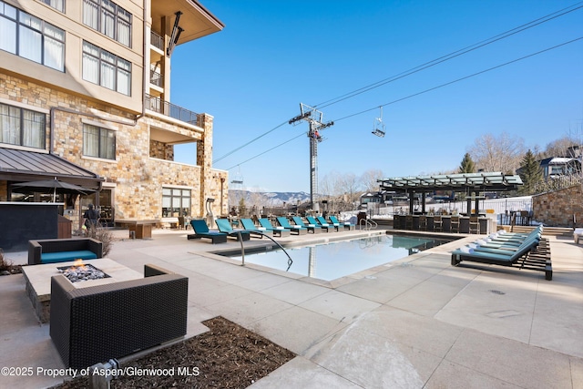 view of pool with a fire pit and a patio area