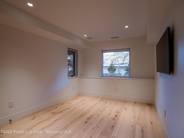 empty room featuring recessed lighting, baseboards, visible vents, and wood finished floors