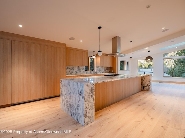 kitchen with decorative backsplash, island exhaust hood, modern cabinets, light wood-type flooring, and a spacious island