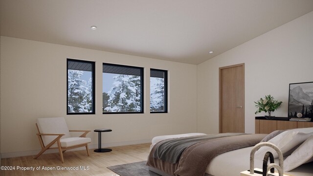 bedroom with light wood-type flooring and vaulted ceiling