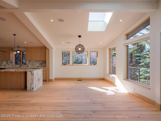 interior space featuring a healthy amount of sunlight, recessed lighting, baseboards, and light wood finished floors