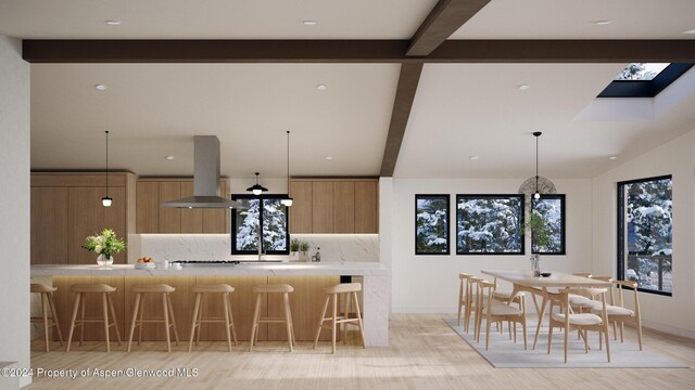 kitchen featuring pendant lighting, light brown cabinets, tasteful backsplash, beamed ceiling, and island range hood