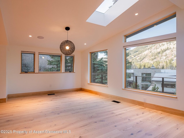 empty room with recessed lighting, visible vents, wood finished floors, and vaulted ceiling with skylight
