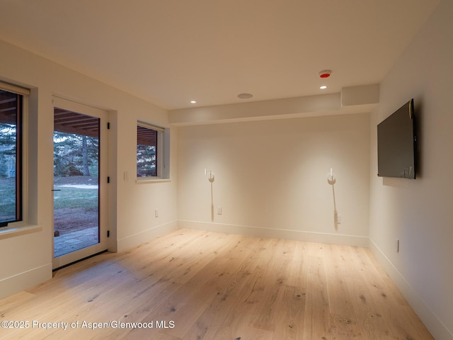 spare room featuring light wood-type flooring, recessed lighting, and baseboards