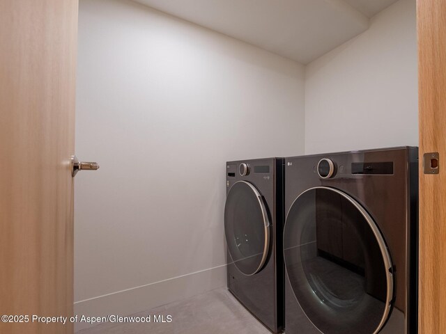 washroom with laundry area, baseboards, and independent washer and dryer