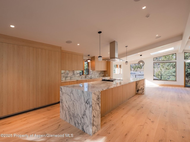 kitchen featuring decorative backsplash, light brown cabinets, modern cabinets, light wood-type flooring, and island exhaust hood