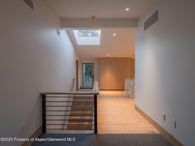 corridor with a skylight, an upstairs landing, recessed lighting, and visible vents