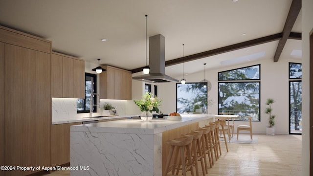 kitchen featuring pendant lighting, a center island, lofted ceiling with beams, sink, and island exhaust hood