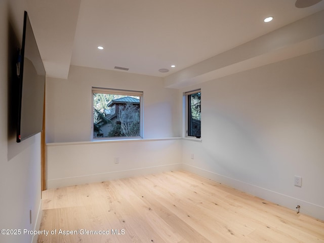 spare room with recessed lighting, baseboards, visible vents, and wood finished floors