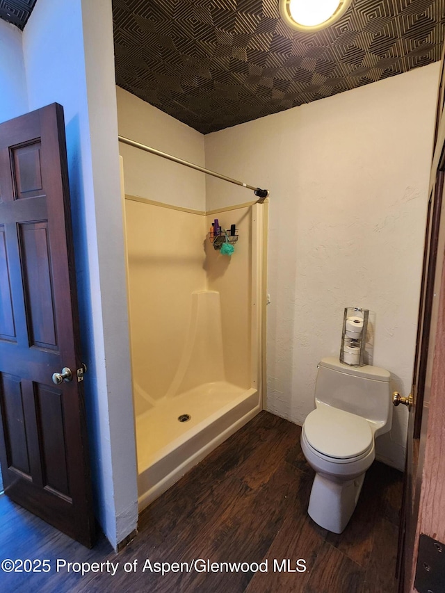 449 County Road 223, Rifle, CO 81650 - bathroom with wood finished floors, a stall shower, toilet, and an ornate ceiling