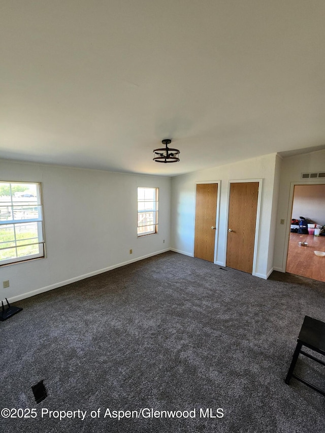 449 County Road 223, Rifle, CO 81650 - unfurnished bedroom featuring carpet flooring, two closets, baseboards, and a chandelier