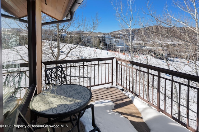 snow covered back of property with a mountain view