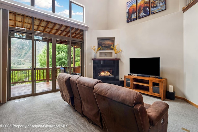 383 Faas Ranch Rd, New Castle, CO 81647 - living area featuring carpet flooring, a high ceiling, and a glass covered fireplace