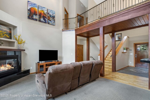 383 Faas Ranch Rd, New Castle, CO 81647 - living area with stairway, a tile fireplace, a high ceiling, wood finished floors, and carpet