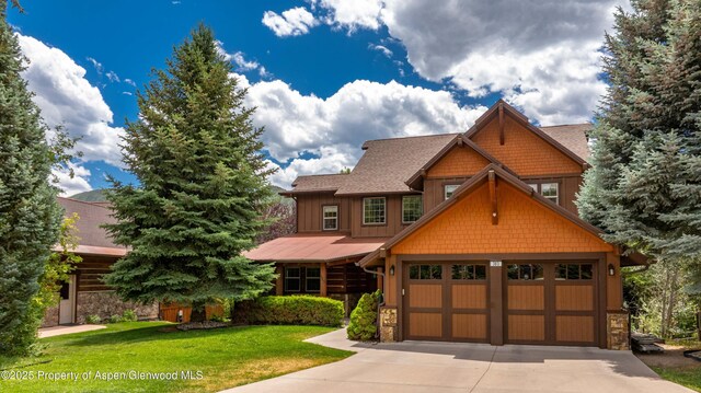383 Faas Ranch Rd, New Castle, CO 81647 - view of front of house featuring concrete driveway, stone siding, a front yard, and a shingled roof