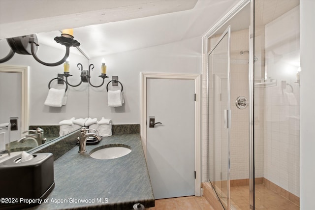 bathroom featuring vanity, walk in shower, and vaulted ceiling