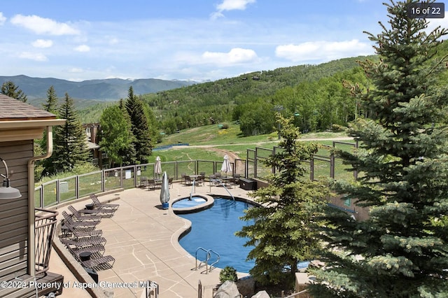 view of swimming pool with a mountain view and a patio