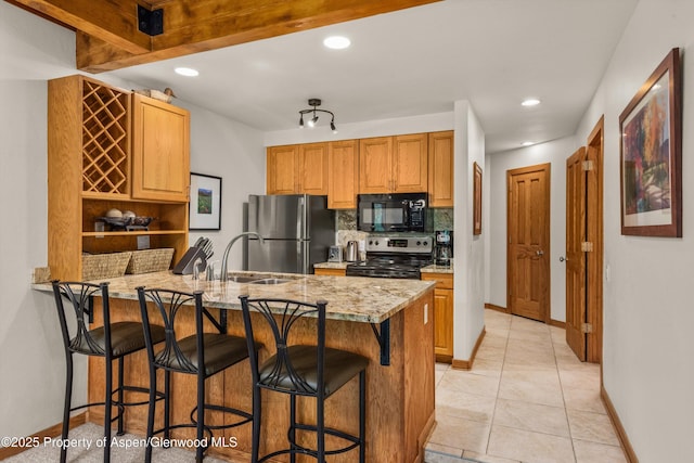 610 S W End St Unit J204, Aspen, CO 81611 - kitchen featuring stainless steel appliances, a sink, a peninsula, decorative backsplash, and baseboards