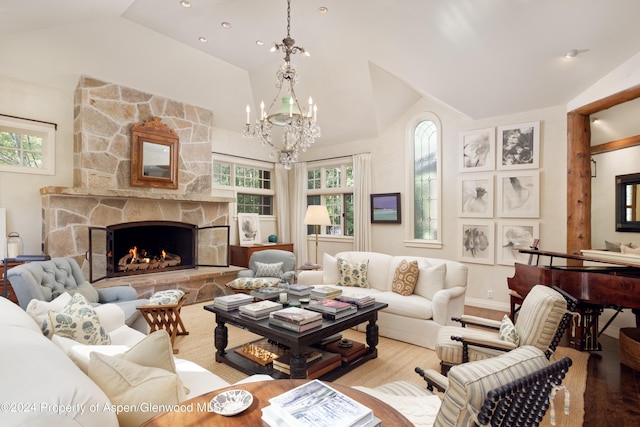 living room with a fireplace, vaulted ceiling, and a notable chandelier