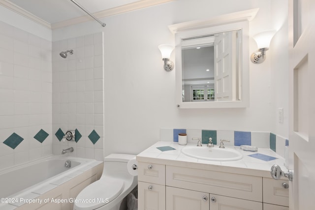 full bathroom featuring vanity, ornamental molding, tiled shower / bath combo, and toilet