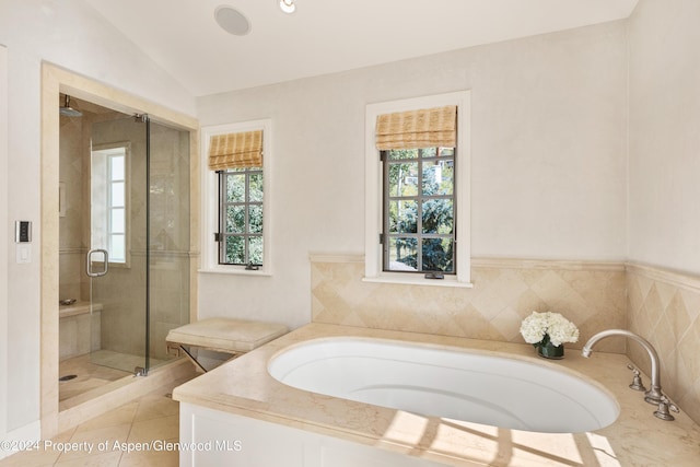 bathroom featuring tile patterned flooring, plenty of natural light, shower with separate bathtub, and vaulted ceiling