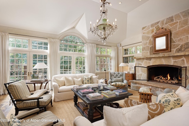 sunroom with a fireplace, french doors, a chandelier, and plenty of natural light