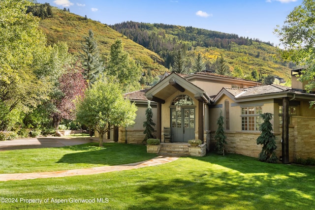 view of front of property featuring a mountain view and a front lawn