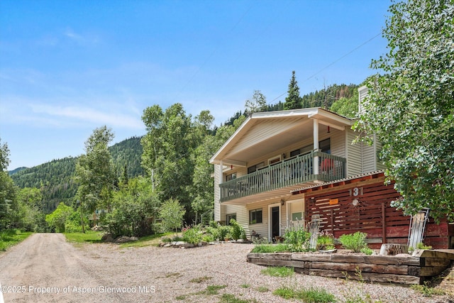 131 Aspen St, Redstone, CO 81623 - view of front facade with a balcony, a wooded view, and a chimney