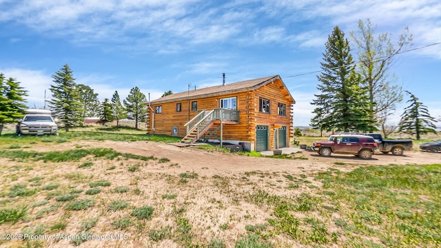 31 Ridge Dr, Craig, CO 81625 - back of house with an attached garage, log exterior, dirt driveway, and stairs