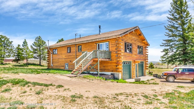 31 Ridge Dr, Craig, CO 81625 - rear view of house with log siding, an attached garage, driveway, and roof with shingles