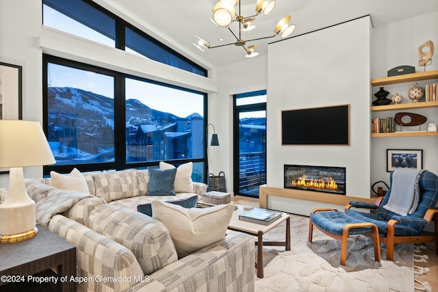 119 Wood Rd Unit 601, Snowmass Village, CO 81615 - living room with a chandelier, wood finished floors, and a glass covered fireplace