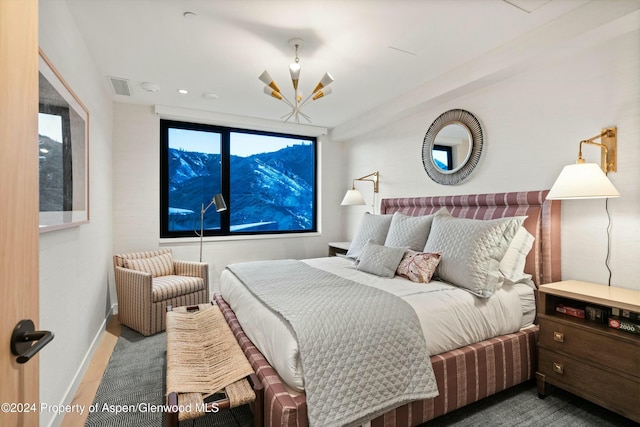 bedroom featuring hardwood / wood-style floors and an inviting chandelier