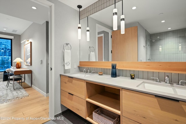 bathroom featuring a shower, hardwood / wood-style floors, and vanity