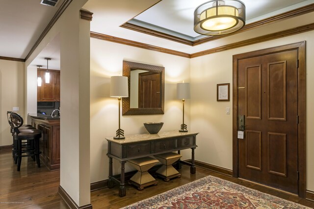 foyer featuring dark hardwood / wood-style flooring, crown molding, and sink