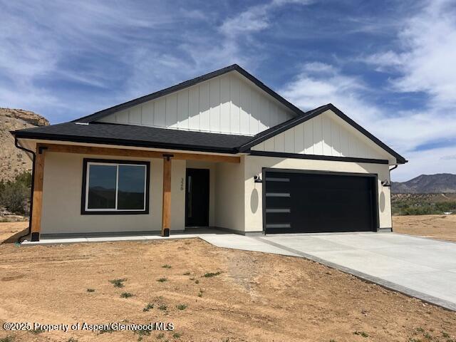 326 W 30th St, Rifle, CO 81650 - modern farmhouse style home featuring an attached garage, concrete driveway, a mountain view, covered porch, and roof with shingles