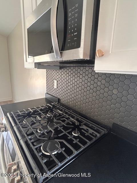326 W 30th St, Rifle, CO 81650 - kitchen view of appliances with stainless steel finishes, decorative backsplash, and white cabinetry