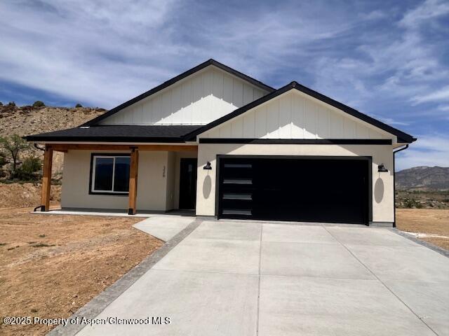 326 W 30th St, Rifle, CO 81650 - view of front of home with an attached garage, concrete driveway, and a mountain view