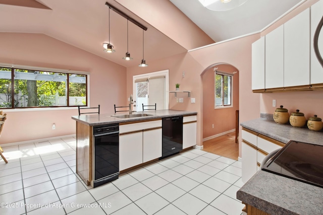kitchen featuring a sink, arched walkways, dishwasher, vaulted ceiling, and white cabinetry