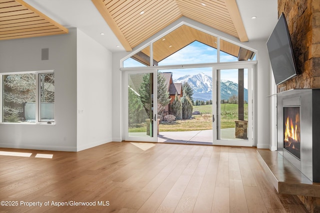 158 Sopris Mesa Dr, Carbondale, CO 81623 - unfurnished living room with baseboards, vaulted ceiling, hardwood / wood-style floors, and a large fireplace
