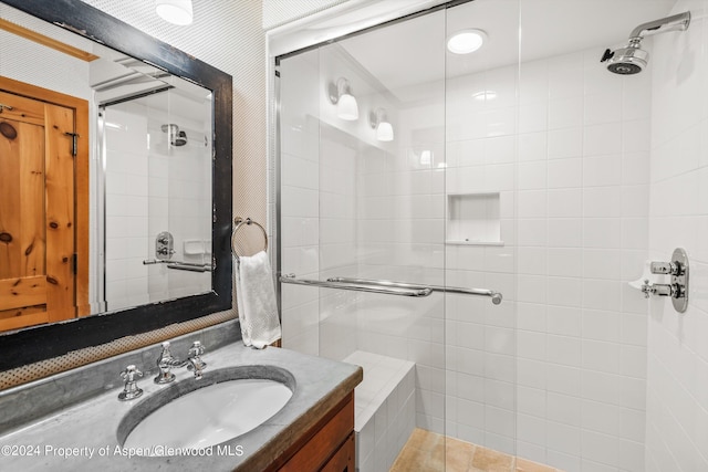 bathroom with tile patterned flooring, vanity, and a shower with door