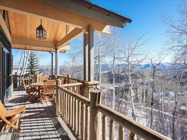 snow covered deck with a mountain view