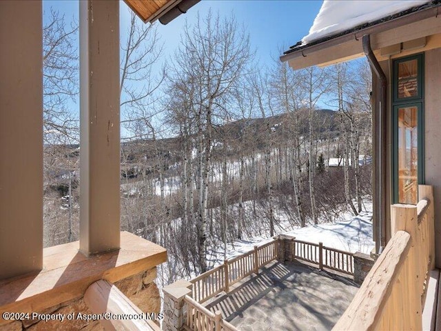 snow covered deck with a mountain view