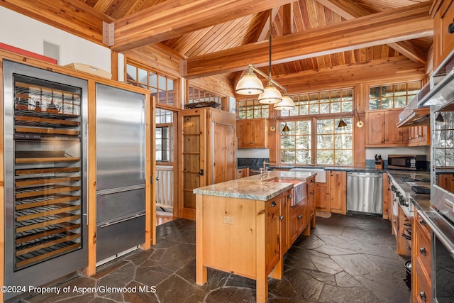 kitchen with stainless steel appliances, beam ceiling, pendant lighting, wooden ceiling, and an island with sink