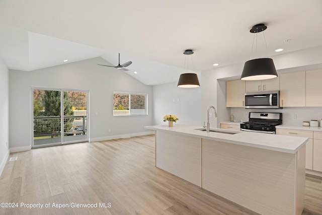 kitchen with appliances with stainless steel finishes, light wood-type flooring, a kitchen island with sink, sink, and hanging light fixtures