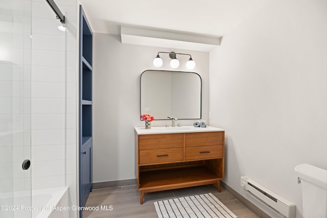 full bathroom featuring a baseboard heating unit, hardwood / wood-style floors, toilet, vanity, and shower / bathtub combination